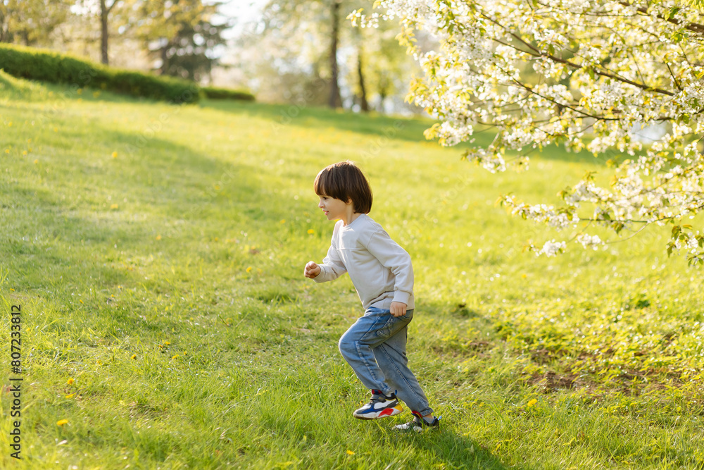 happy little cute boy running on children playground, green nature sunny background, happy freedom childhood. happy little cute boy running on children playground, green nature sunny background, happy freedom childhood.