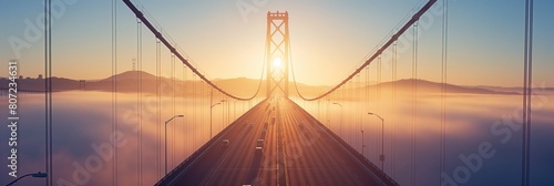 Majestic view of the Golden Gate Bridge enveloped in morning fog with rising sun in the background creating a serene and tranquil atmosphere photo