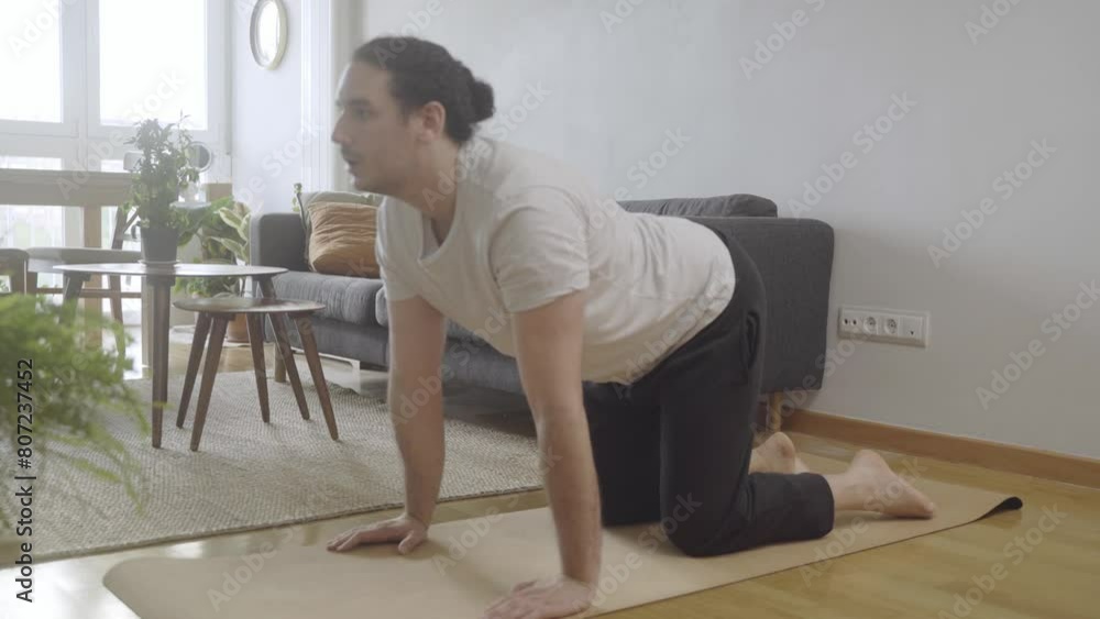 Cat posture. Young male doing yoga and stretching at home Cat posture. Young male doing yoga and stretching at home