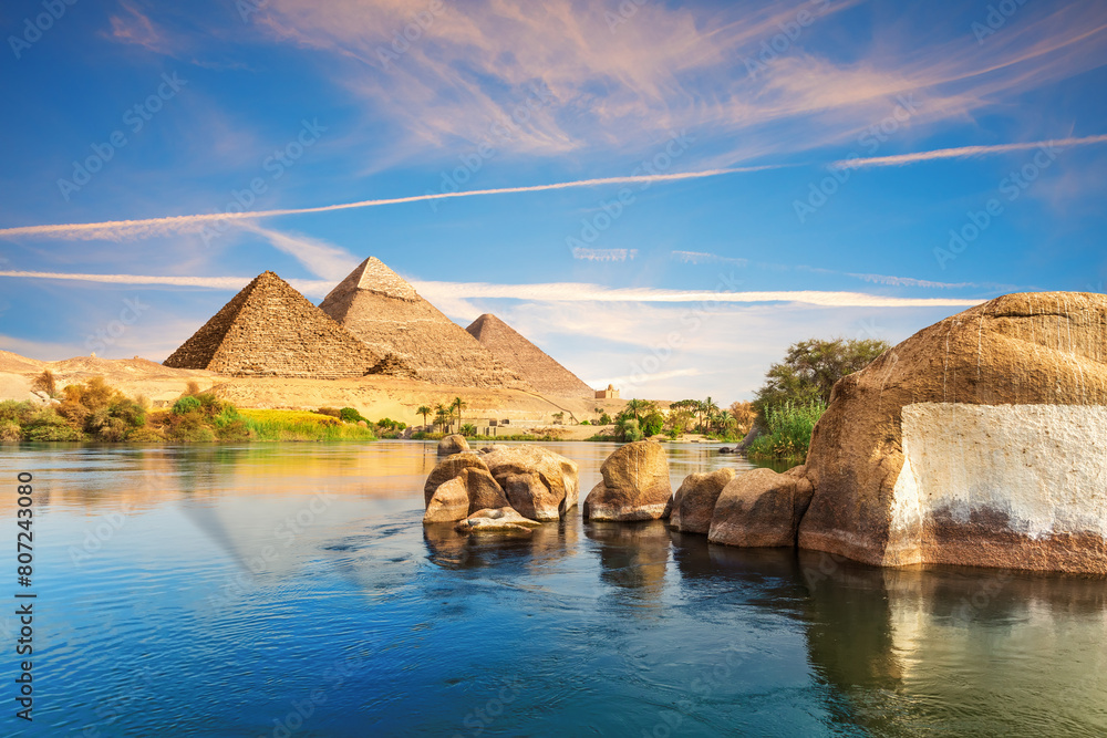 Sunset over the Nile river with ancient rocks on the way to pyramids, Aswan, Egypt