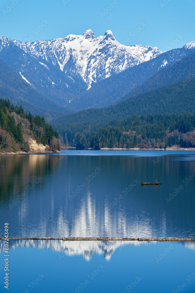© maxdigi - Capilano Lake Lions Peaks Reflection North Vancouver vertical.
