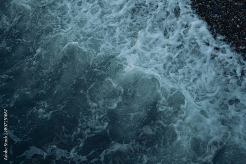 water flowing, waves on a stone beach