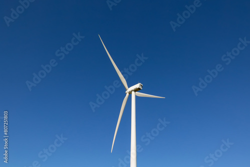 windmill of wind energy in the middle of the countryside with beautiful colors and clear blue sky, renewable energy