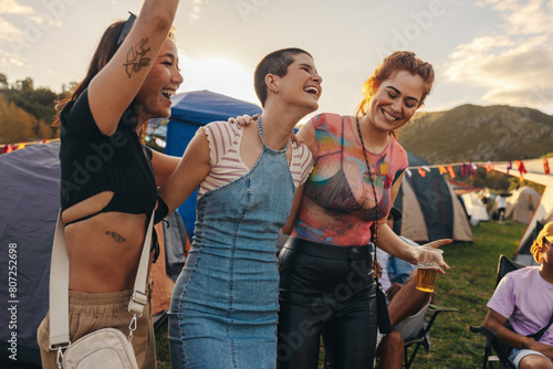 Three young women enjoying unforgettable moments of laughter and celebration at a summer festival photo