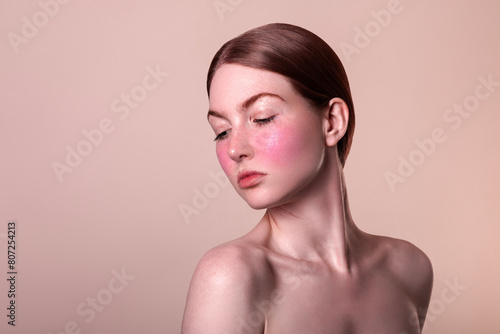 rosacea couperose redness skin, red spots on cheeks, young beautiful red-haired woman with sensitive skin, ipl laser treatment, patient face close-up isolated on beige background