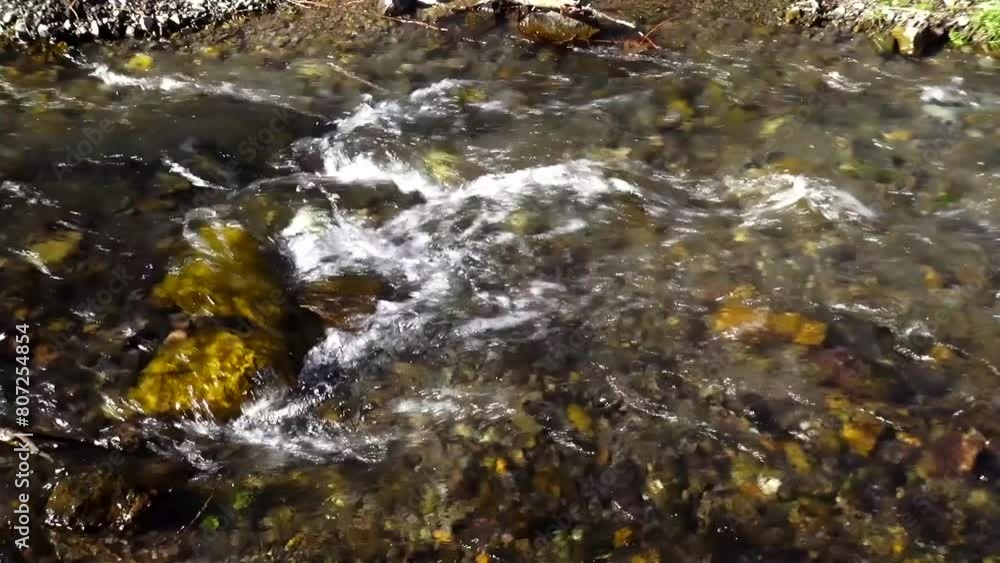 High Close-Up of Water Stream Flowing Over Flat Stone, Creating Mesmerizing Waves. High Close-Up of Water Stream Flowing Over Flat Stone, Creating Mesmerizing Waves.