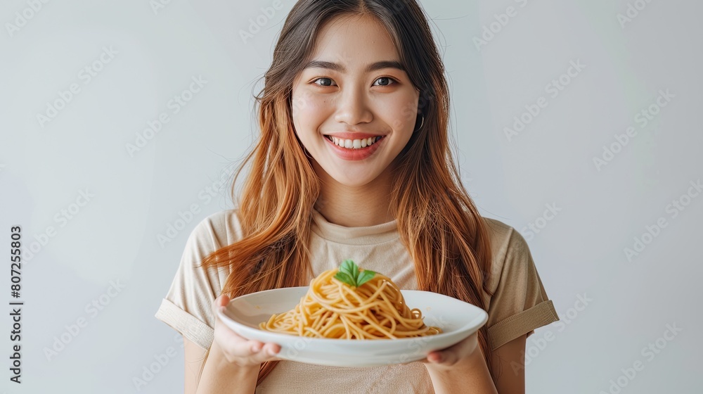 Filipina woman is holding a plate with pasta spaghetti, against white background. Filipina woman is holding a plate with pasta spaghetti, against white background.