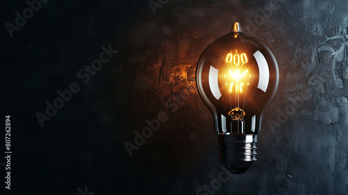 A single light bulb glowing brightly against a dark background, symbolizing ideas, innovation, and creativity.