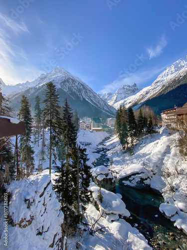 Beautiful winter landscape with ski huts next to the ski slope and forest.