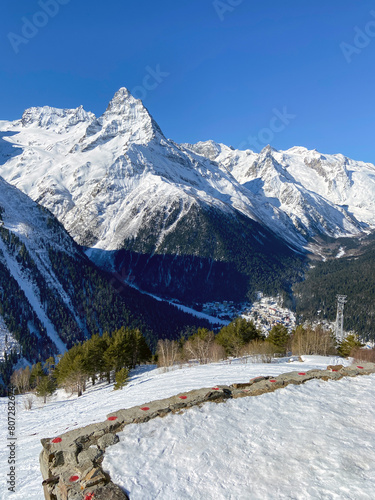 Landscape view of beautiful mountains with a ski slope and fir forest in sunny weather