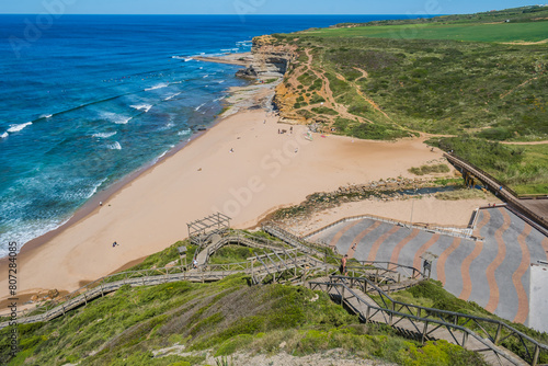 Walkway on a hill in aerial view with sand and bridge over river at Ribeira D'Ilhas beach, Ericeira - Mafra PORTUGAL