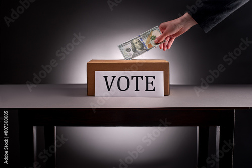 Hand in suit puts hundred dollar bill into voting box