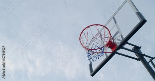 Basketball shot in hoop against blue sky