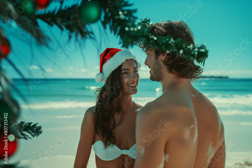 Couple sur la plage des caraïbes au soleil avec un bonnet de noel. sourires photo