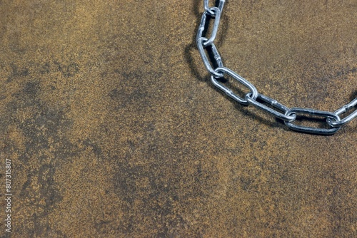 A section of shiny metal chain in the corner of the frame.