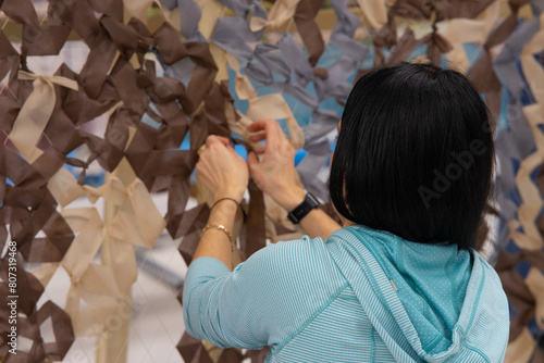 volunteers weave camouflage nets. photo