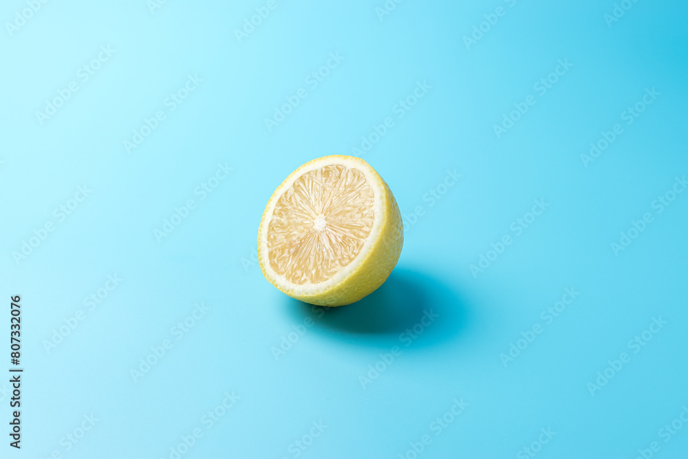 Fresh sliced lemon on blue background. Minimal food concept.