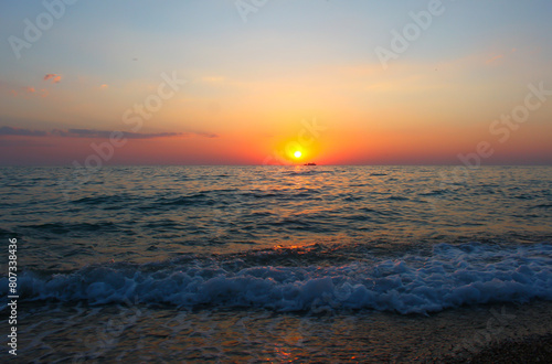 A beautiful sunset over the sea with orange clouds  and a calm tide
