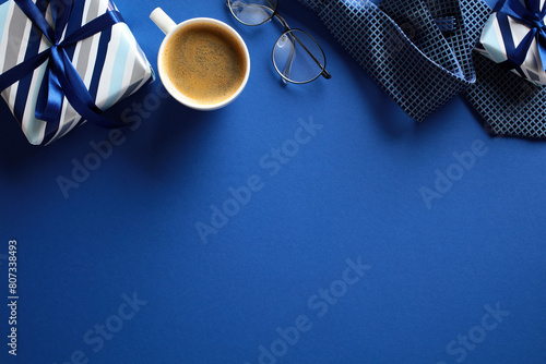 Happy Fathers Day concept. Top view vintage gift boxes, coffee cup, necktie, glasses on dark blue background.