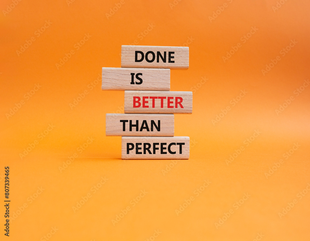 Naklejka premium Done is better than Perfect symbol. Wooden blocks with words Done is better than Perfect. Beautiful orange background. Business concept. Copy space.