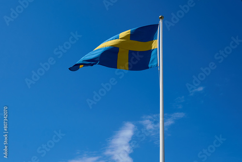 Swedish flag on blue sky. Swedish flag fluttering on wind. National Day of Sweden. Swedish Flag Day.  