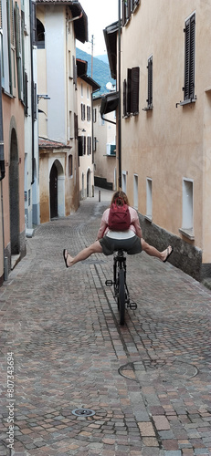 adult biking in a italy narrow street