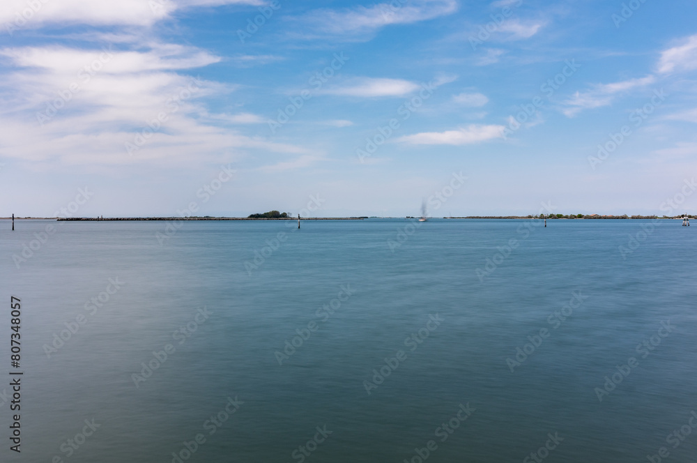 Panorama of the sky and sea in Grado, Italy with long exposure sunny day, view of the rocks.