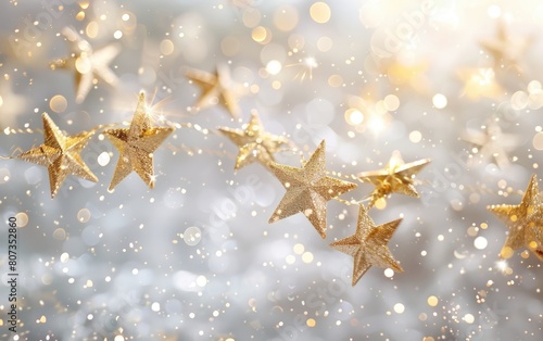Soft golden stars twinkling on a bright white background. © OLGA