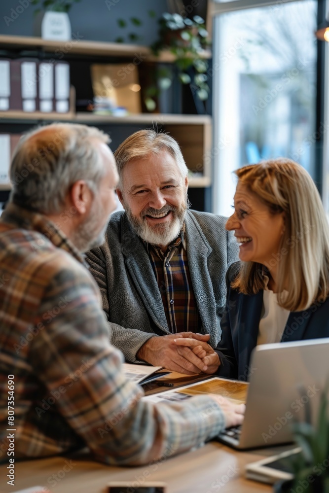 A man and a woman sitting together at a table with a laptop. Ideal for business or technology concepts A man and a woman sitting together at a table with a laptop. Ideal for business or technology concepts