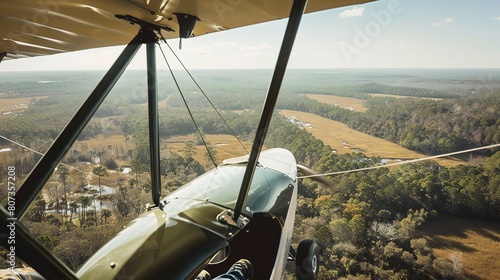 Ultralight aircraft over savannah, close-up of cockpit and expansive wildlife below  photo