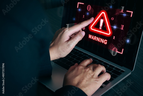 Warning sign alert on laptop screen. System hack, cybersecurity, cyber attack, phishing scams. photo