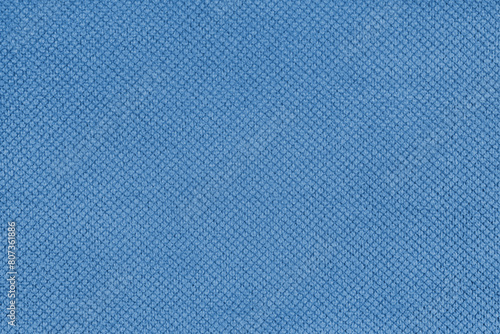 Plain blue velor upholstery fabric, jacquard with fine diamond texture background. Close up, macro cloth textile surface. Wallpaper, backdrop with copy space