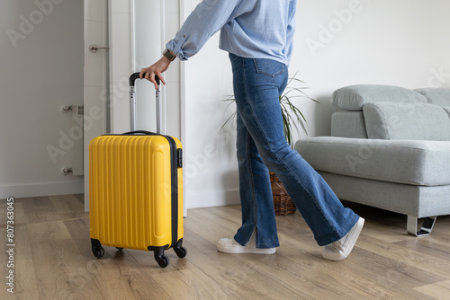 Women leaving home with travel suitcase