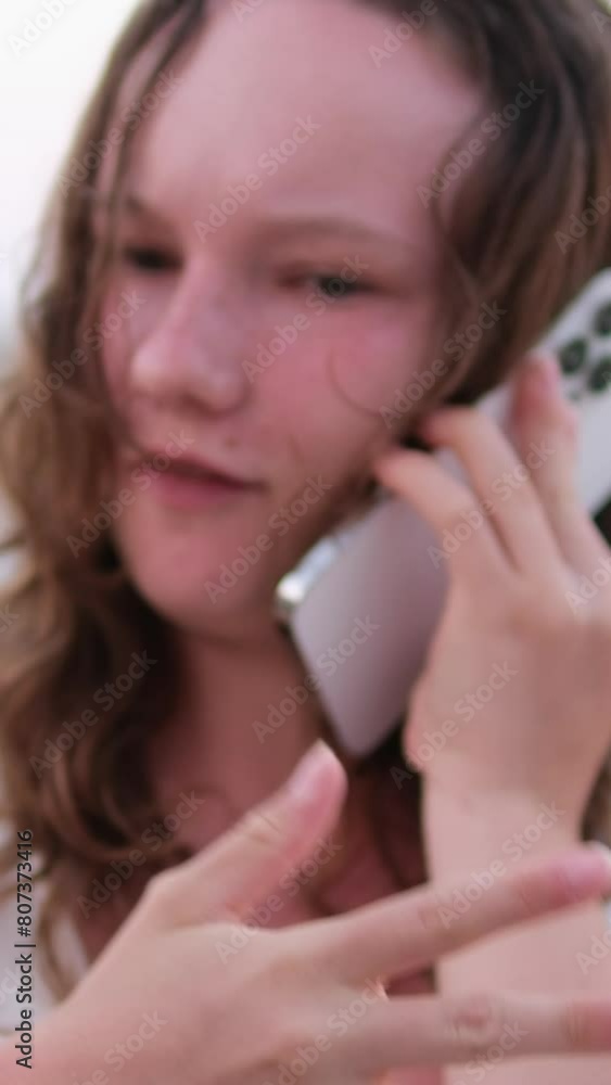 A woman talks on the phone, ordering delivery, communicates with friends, uses social networks and the Internet. Relaxing on beach emotions of young girl burnt skin red cheeks wet hair. A woman talks on the phone, ordering delivery, communicates with friends, uses social networks and the Internet. Relaxing on beach emotions of young girl burnt skin red cheeks wet hair.