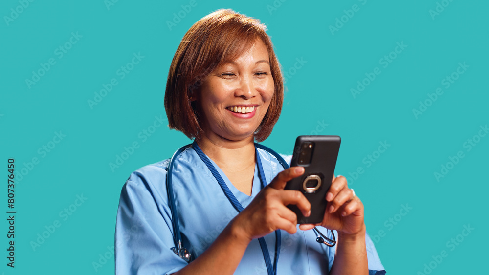 Jubilant nurse having burst of joy at work while chatting with friends, isolated over studio background. Elated hospital worker delighted about great news she received over the phone, close up Jubilant nurse having burst of joy at work while chatting with friends, isolated over studio background. Elated hospital worker delighted about great news she received over the phone, close up