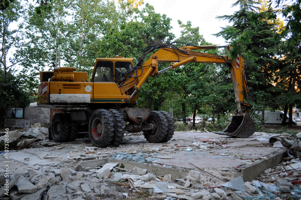 A large excavator flattens and breaks the remains of the building it demolished. A large excavator flattens and breaks the remains of the building it demolished.
