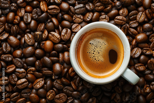 Mug with espresso on coffee beans. Top angle, copy space.  © Karim Boiko