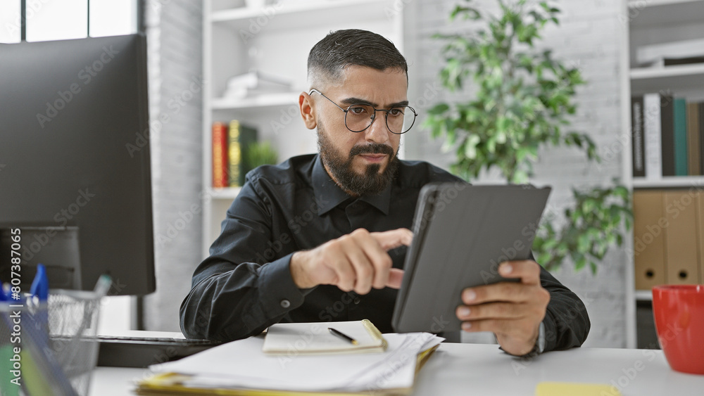 Bearded man using tablet in modern office, conveying professional, focused, and technology-driven atmosphere. Bearded man using tablet in modern office, conveying professional, focused, and technology-driven atmosphere.