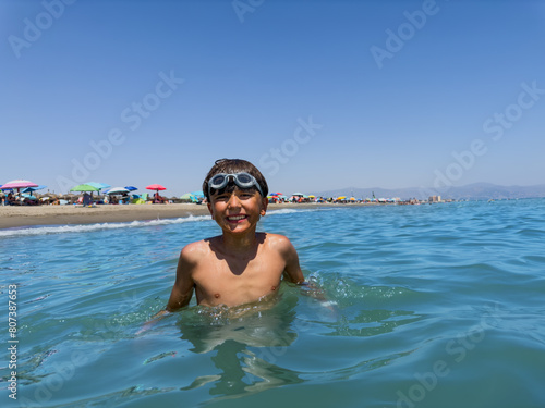 A smiling young swimmer with goggles take pleasure in clear sea © Sergey Novikov