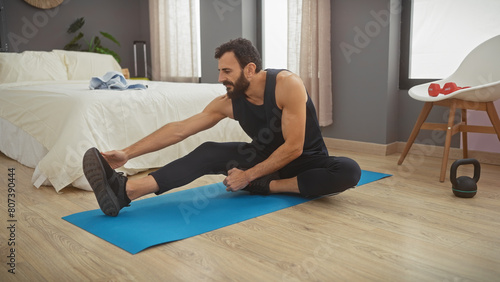 A mature man stretching on a yoga mat in a modern bedroom setting