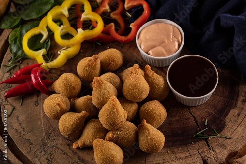 Porção de mini coxinhas acompanhada de molhos