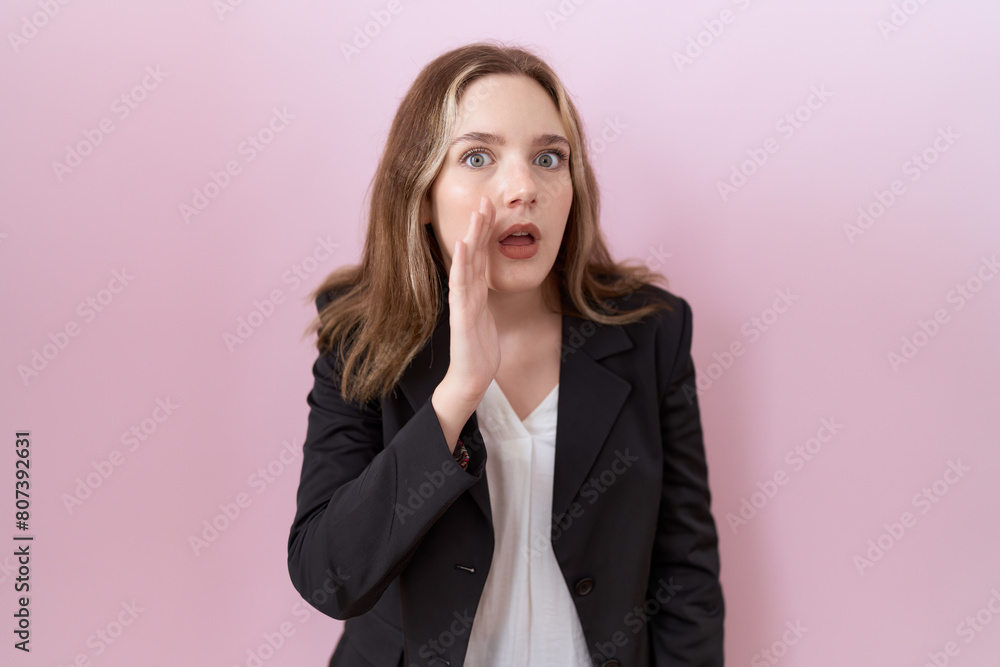 Young caucasian business woman wearing black jacket hand on mouth telling secret rumor, whispering malicious talk conversation Young caucasian business woman wearing black jacket hand on mouth telling secret rumor, whispering malicious talk conversation