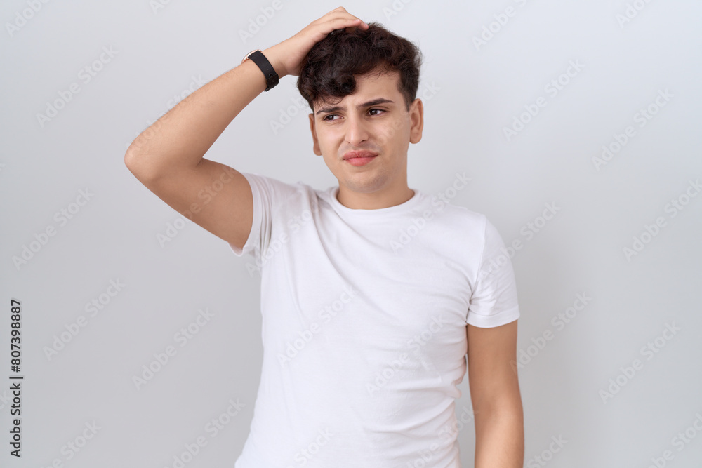 Young non binary man wearing casual white t shirt confuse and wondering about question. uncertain with doubt, thinking with hand on head. pensive concept. Young non binary man wearing casual white t shirt confuse and wondering about question. uncertain with doubt, thinking with hand on head. pensive concept.