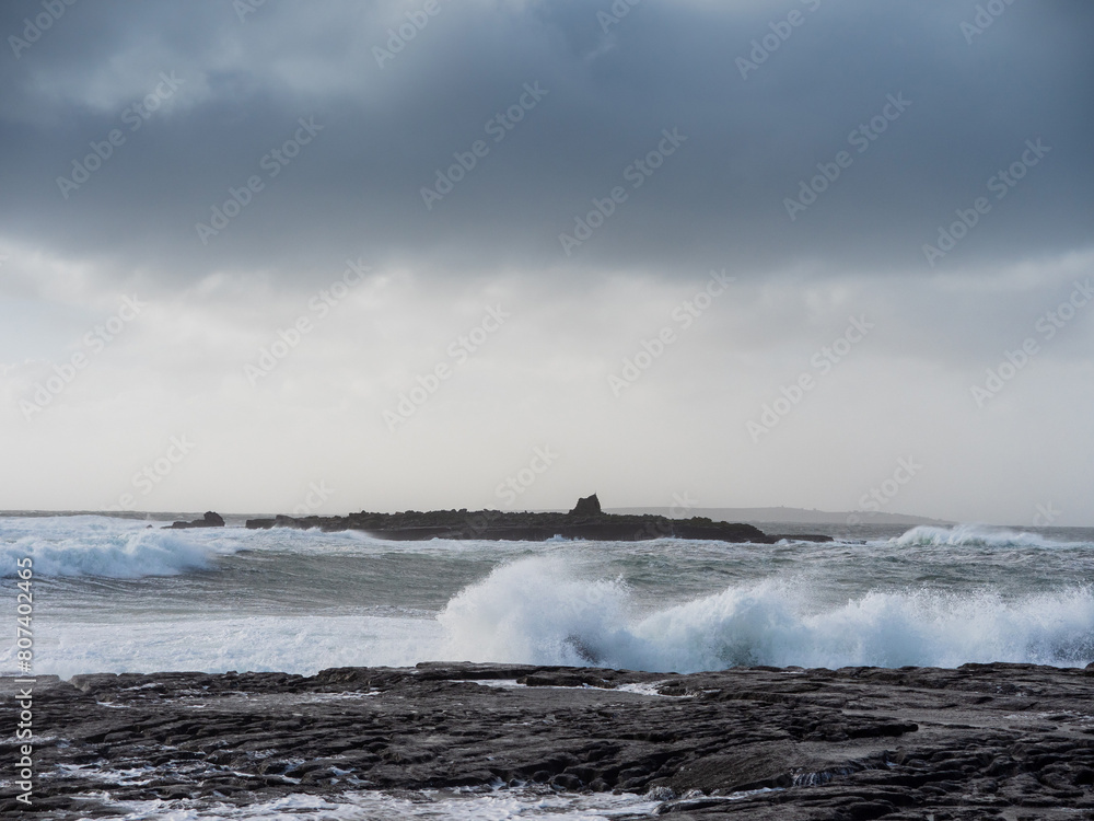 Powerful ocean wave hit rough stone coast in Doolin pier area, county Clare, Ireland. Stunning nature scene in popular tourist area with amazing nature scenery. Nobody. Storm weather. Power of nature
