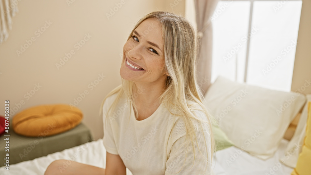 Young blonde woman smiling confident sitting on sofa at bedroom Young blonde woman smiling confident sitting on sofa at bedroom