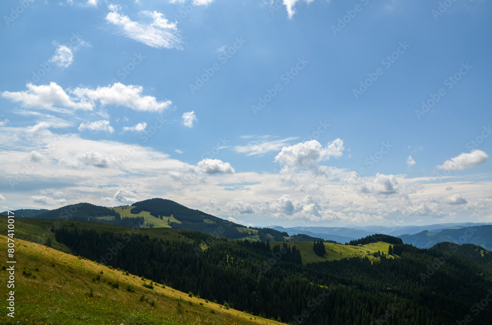 Lush green mountain landscape with undulating rolling hills and mountains covered in vibrant greenery and green forests at summer day. Carpathians, Ukraine 