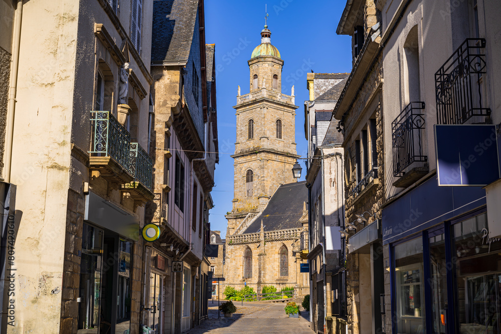 View of the Saint-Gildas church among the buildings in the center of the village. Photography taken in Auray, Brittany, France.