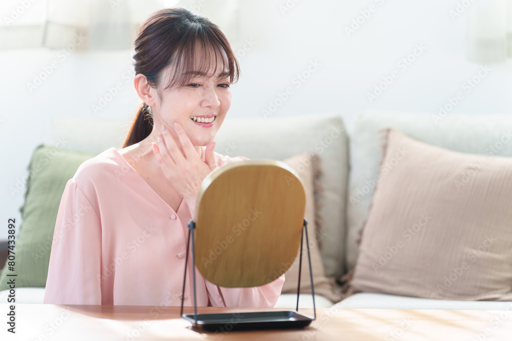 リビングで鏡を見る女性　スキンケア　アンチエイジングイメージ
