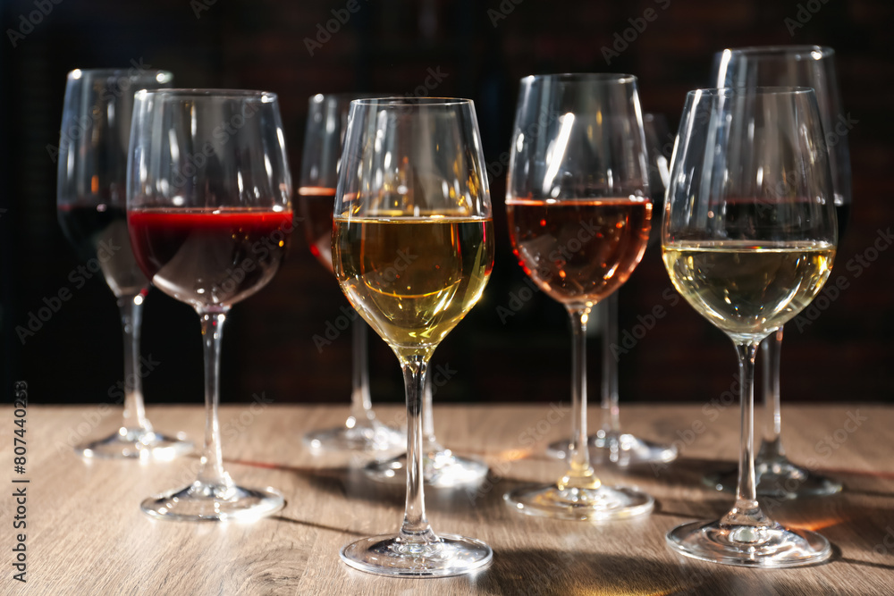 Different tasty wines in glasses on wooden table Different tasty wines in glasses on wooden table