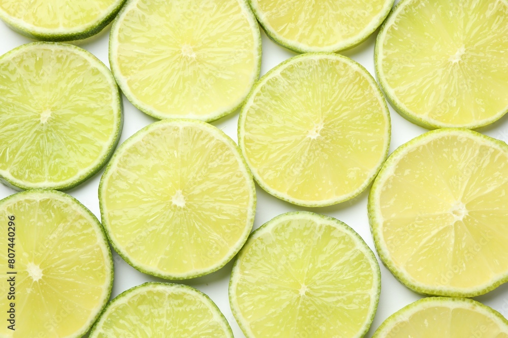 Fresh juicy lime slices on white background, flat lay Fresh juicy lime slices on white background, flat lay